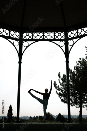 Yoga tree pose silhouette under pavilion – mindfulness and balance outdoors