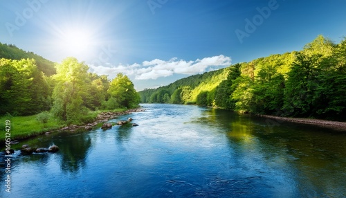 serene river flows through lush green forest under bright blue sky with sunlight glistening on water surface creating peaceful atmosphere