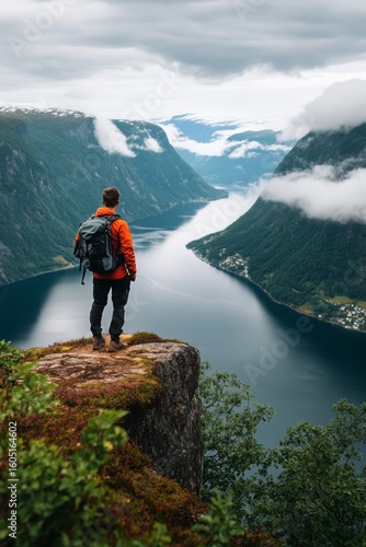 Hiker Enjoying Breathtaking Views of Fjord Under Cloudy Sky in Norway