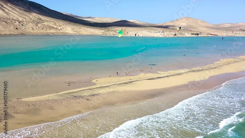 Aerial view of a crowd of kitesurfers enjoying the waves on the beach of Sotavento, Fuerteventura Island, Spain.