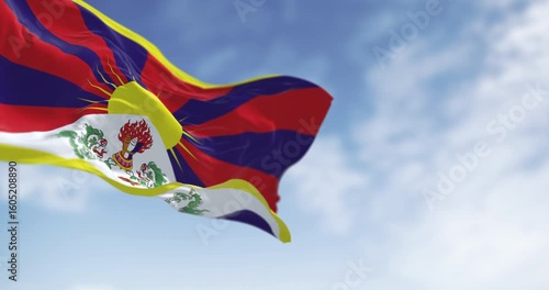 Tibetan flag waving outdoors with snow lions and rising sun symbolizing freedom