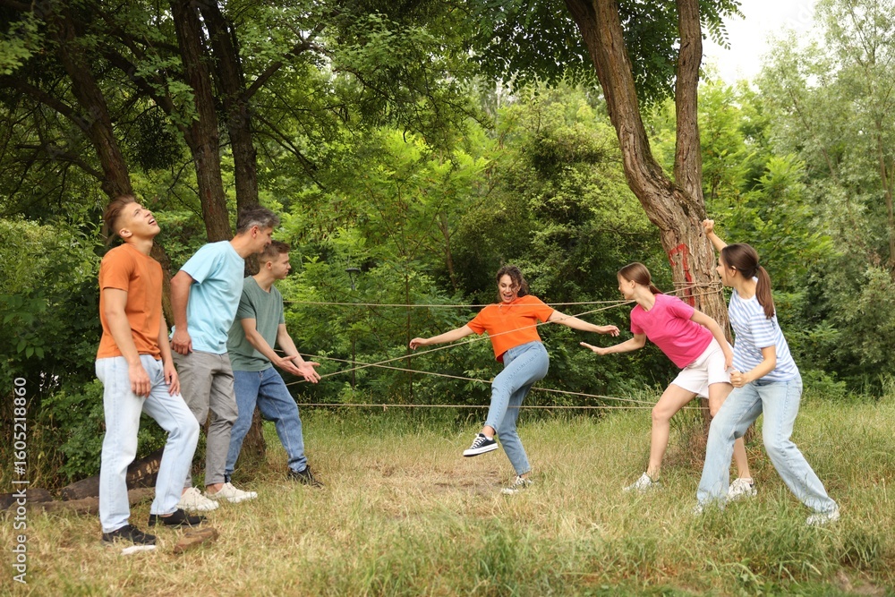 Obraz premium Team building. Group of happy people playing spider web game outdoors