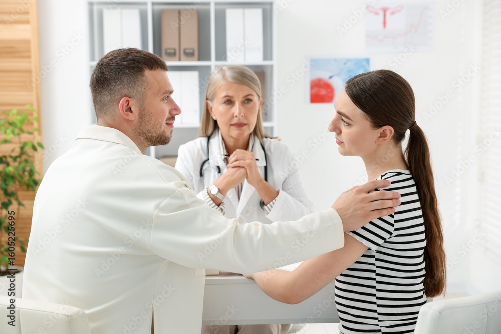 Obraz premium In vitro fertilization (IVF). Couple having consultation with doctor in reproductive clinic, selective focus