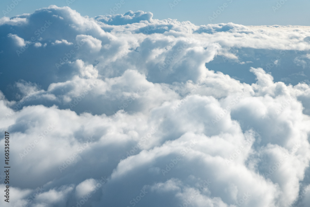 A thick sea of clouds stretches into the distance with soft undulations captured from above in an aircraft A thick sea of clouds stretches into the distance with soft undulations captured from above in an aircraft