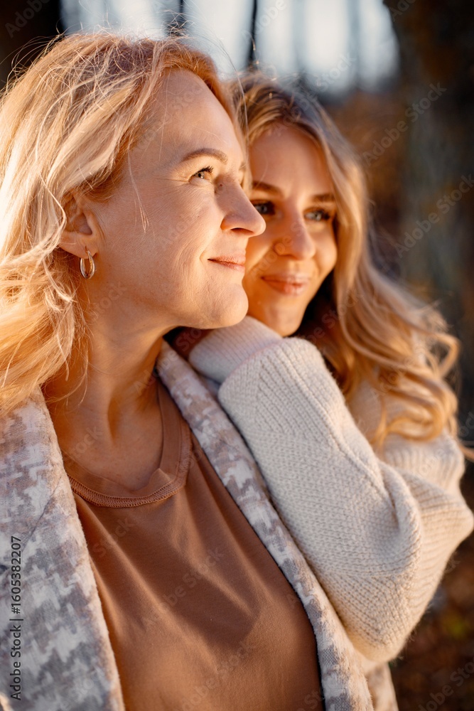 Fototapeta premium Portrait of mother and daughter hugging at autumn park