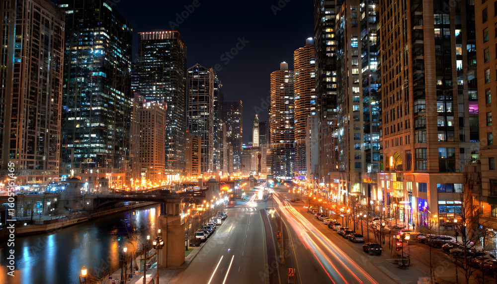 Fototapeta premium Nighttime city skyline with glowing windows and streetlights, capturing urban vibrancy.