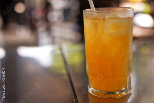 Tablou pe pânză A glass of iced orange juiced with blurred background, A refreshing drink for ho
