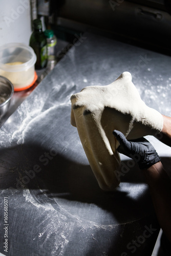 Pizza chef stretching dough in a professional kitchen