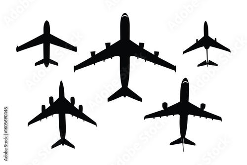 Airplanes silhouettes in Flight: High-angle view of five airplanes of various sizes and designs captured in striking silhouettes against the light.