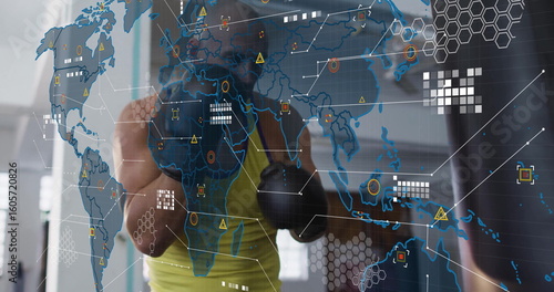 Punching trainee wearing green top, black gloves striking heavy bag at gym, with digital overlay