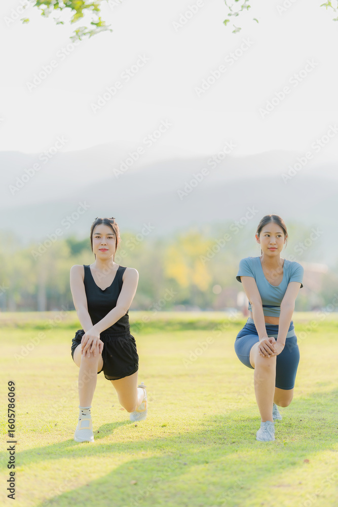 Two Asian girls stretching and exercising in the park, health concept. Two Asian girls stretching and exercising in the park, health concept.