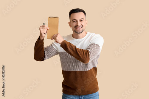 Happy young man with notebo...