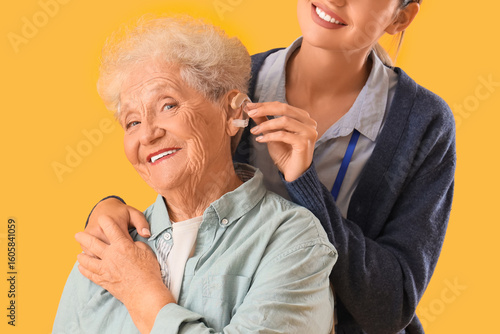 Nurse putting hearing aid o...
