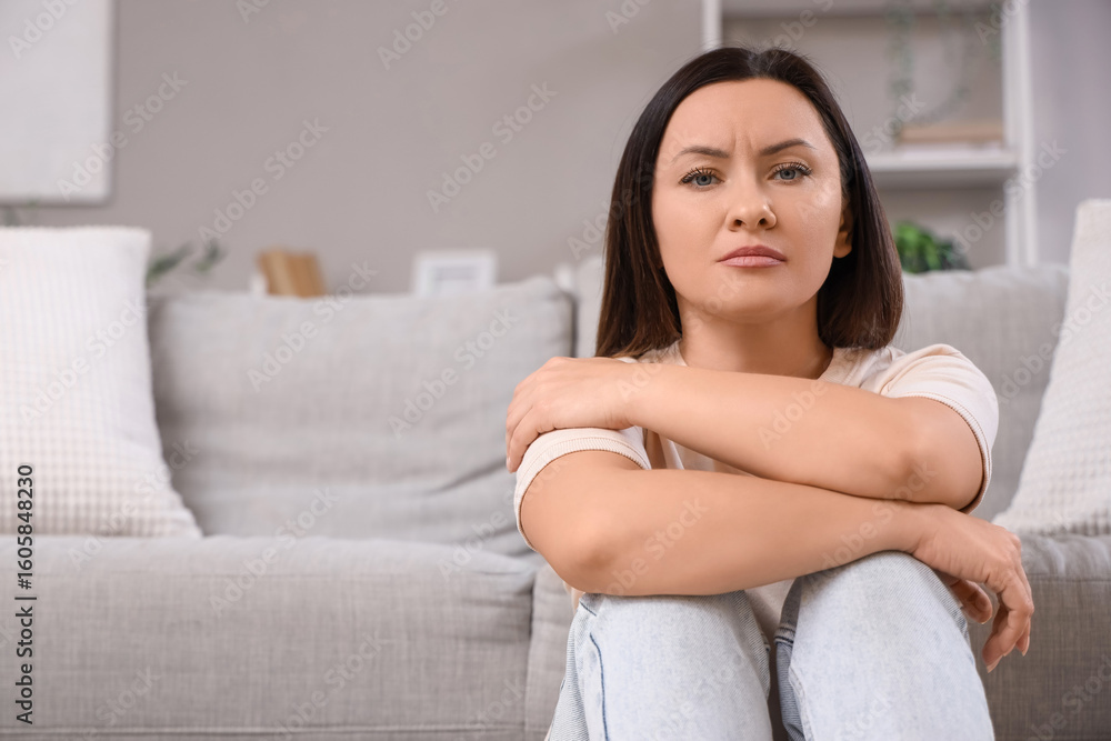 Worried woman sitting on floor at home Worried woman sitting on floor at home