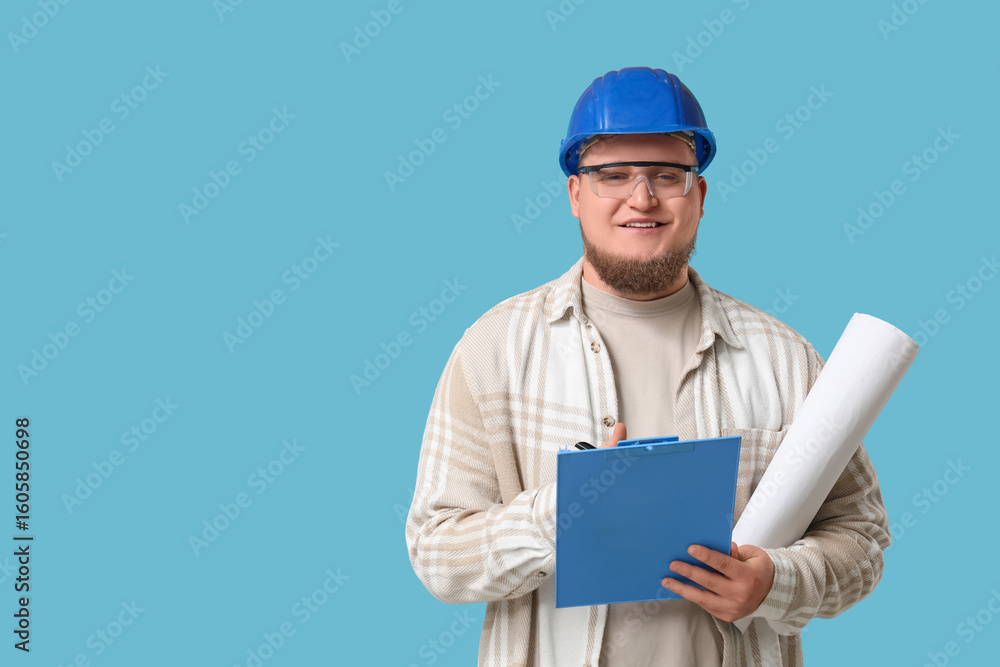 Young male engineer with clipboard and drawing on blue background Young male engineer with clipboard and drawing on blue background
