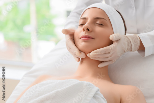 Young woman getting facial ...