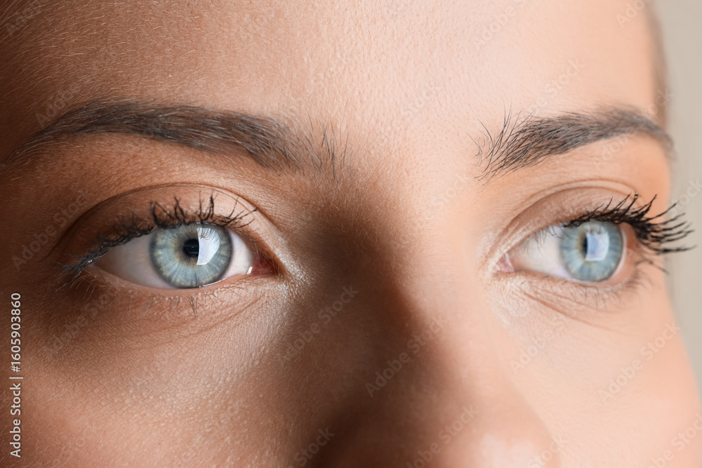 Naklejka premium Young woman with beautiful blue eyes, closeup