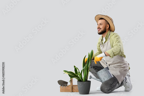 Male gardener watering plan...