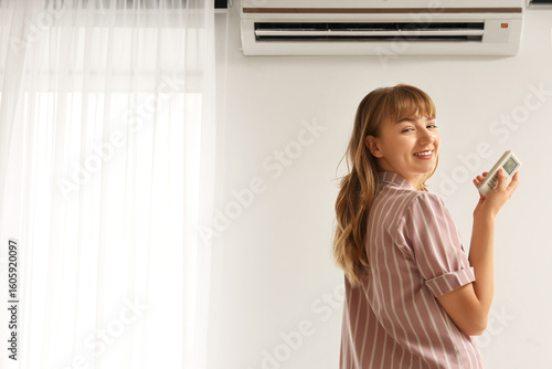 Young woman near air condit...