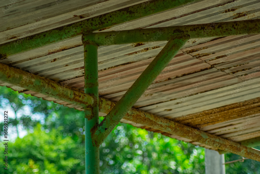 Obraz premium Rusted metal scaffolding supports a corrugated metal roof
