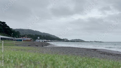 芝生の先にある海の家と曇り空と初夏の海