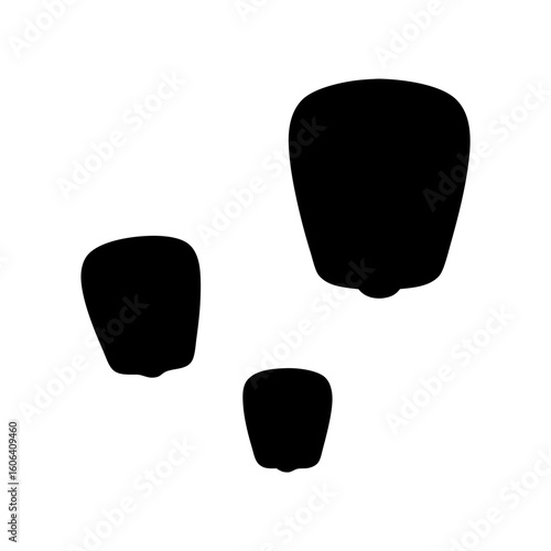 Three floating sky lanterns in the night sky casting dark shadows