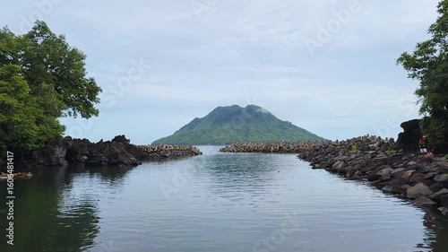 Wallpaper Mural The striking basalt outcrop known as Black Rock, located on Ternate Islands, surrounded by clear turquoise tropical ocean and reef. Torontodigital.ca