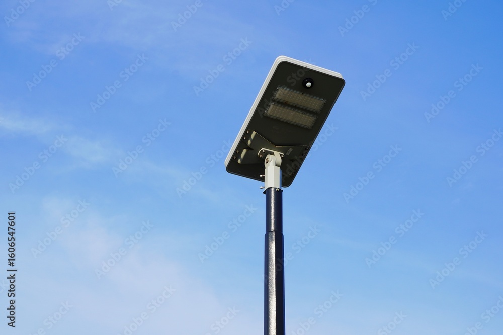 Solar-Powered Street Light with Blue Sky. A solar cell street light. tight Street lamp with a light cloudy blue sky Solar-Powered Street Light with Blue Sky. A solar cell street light. tight Street lamp with a light cloudy blue sky