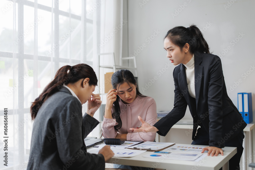 Asian businesswoman scolding her colleagues during a meeting Asian businesswoman scolding her colleagues during a meeting