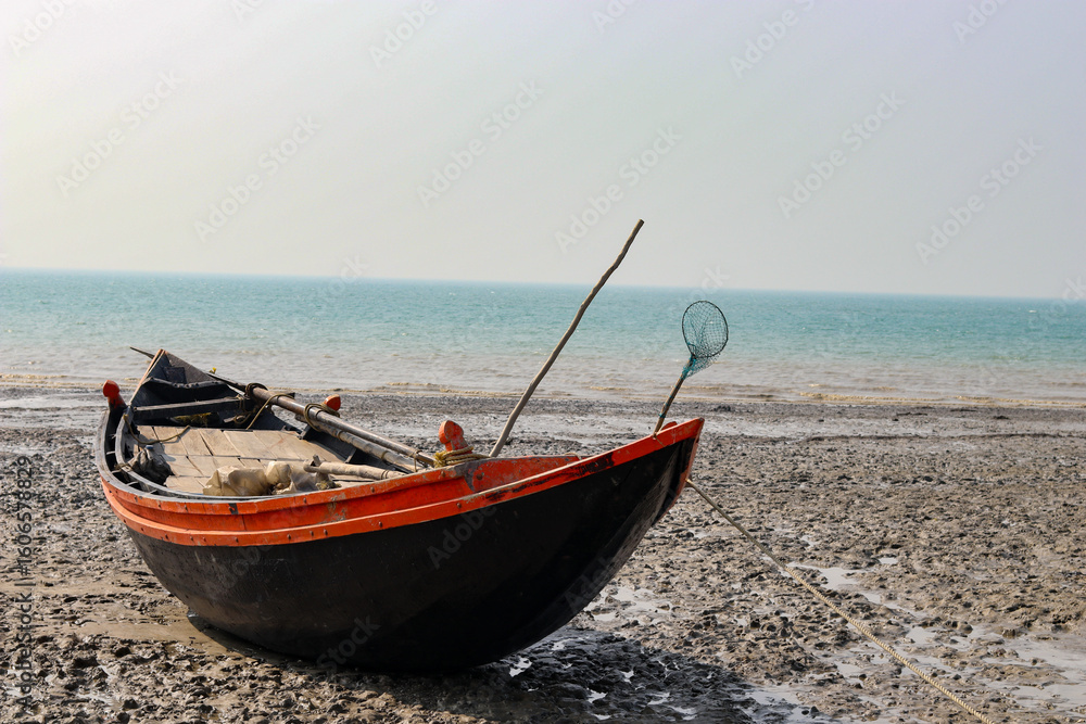 Fototapeta premium fishing boat on the beach at sunset in mousuni Island