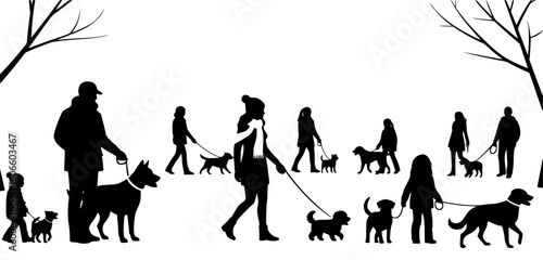Silhouettes of people walking dogs in a snowy park during winter