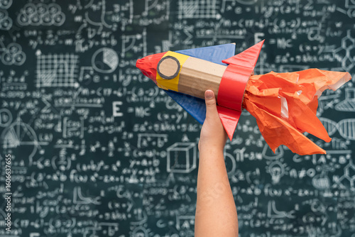 Wallpaper Mural Hand Holding Toy Rocket with Flames in Front of Blackboard Filled with Math and Science Formulas Torontodigital.ca
