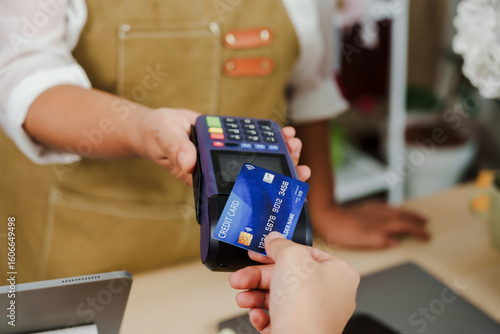Obraz na płótnie Senior asian florist handing credit card terminal to customer receiving electron