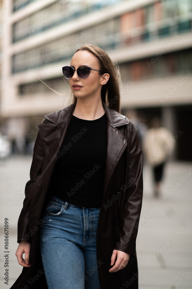 Obraz premium Elegant young woman walking confidently in urban area