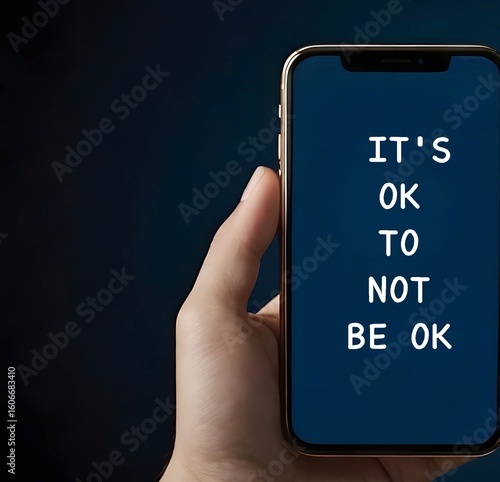 Hand holding mobile with text written IT'S OK TO NOT BE OK, means feelings and emotions expressing are valid no matter what they are, its normal to say you are not okay