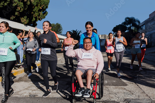 Latin young man on wheelchair competing in a marathon race in the streets in Mexico Latin America, diverse group of hispanic runners, social inclusion concept