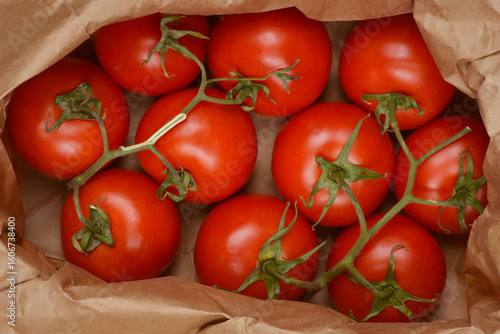 Foto A close-up, top-down view reveals numerous fresh, ripe red tomatoes on the vine,
