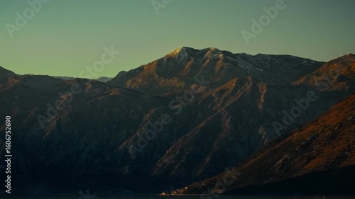A timelapse of night turning into morning, illuminating the peaks of high mountains the sun rises in the mountains and night fades into dawn