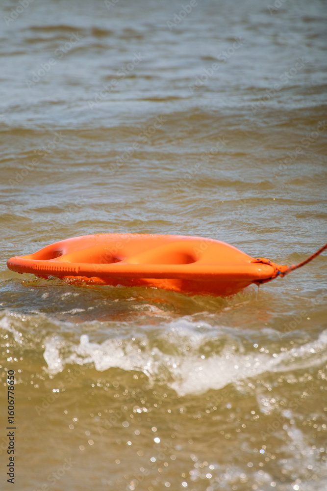Obraz premium Lifeguard rescue float on the water with waves and splashing water