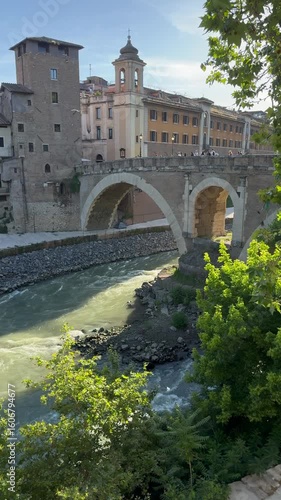 The Tiber River flows under the Fabricius Bridge on the side of Tiber Island in the center of Rome.