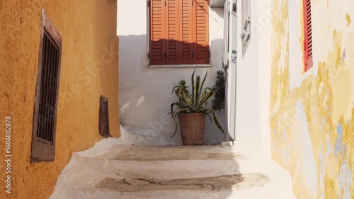 Wallpaper Mural Narrow sunlit alley in Anafiotika, Athens, Greece with old textured walls, white stairs and Mediterranean plants, no people, summer light and shadows, traditional architecture Torontodigital.ca