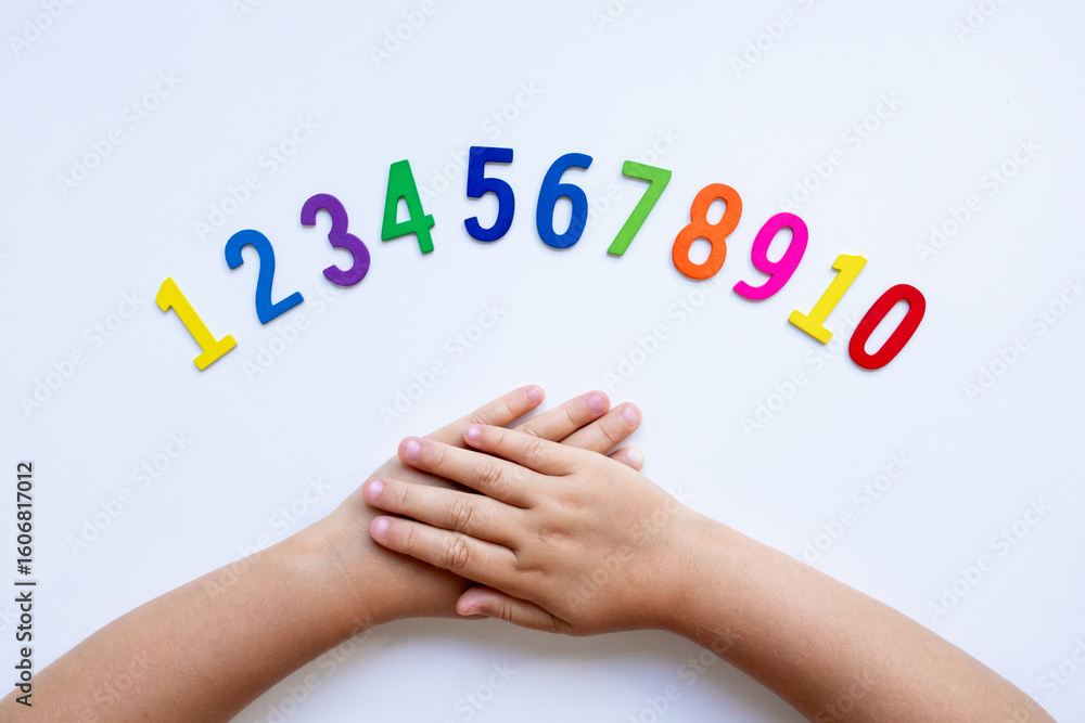 Fototapeta premium Child hands with colorful numbers on white background