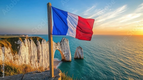 Flag France tricolor banner positioned on clifftop overlooking Normandy's famous white chalk formations and emerald sea at dusk
