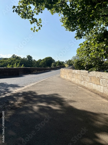 Wallpaper Mural View looking across an old Roman single lane road bridge in bright sunlight with shadows being formed. Torontodigital.ca