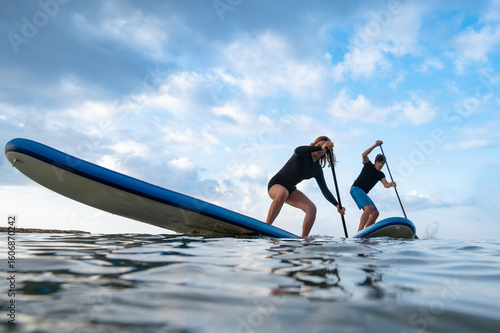 Water sport fun: couple racing on paddleboards
