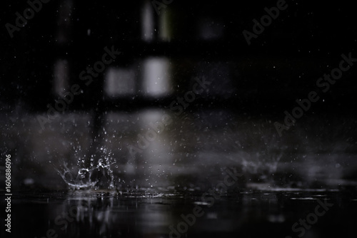 heavy raining make many small splash crown from water droplets drop down to the concrete floor in blue tone color scene