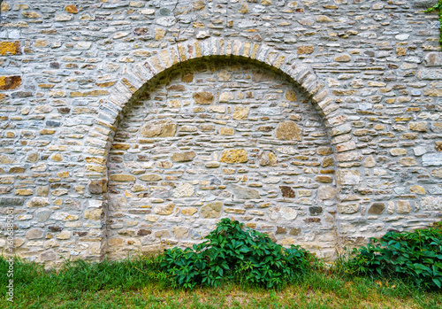 old stone wall with arch create a frame with blank space, close up of beautiful and cozy architectural details