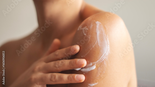 Woman applying body cream on arm, beauty skin care concept