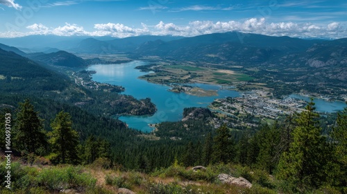 Mountain lake view, surrounded by forest and mountain range, with town next to lake