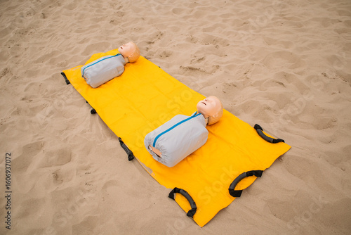 Medical dolls lay on the yellow mat for rescue training